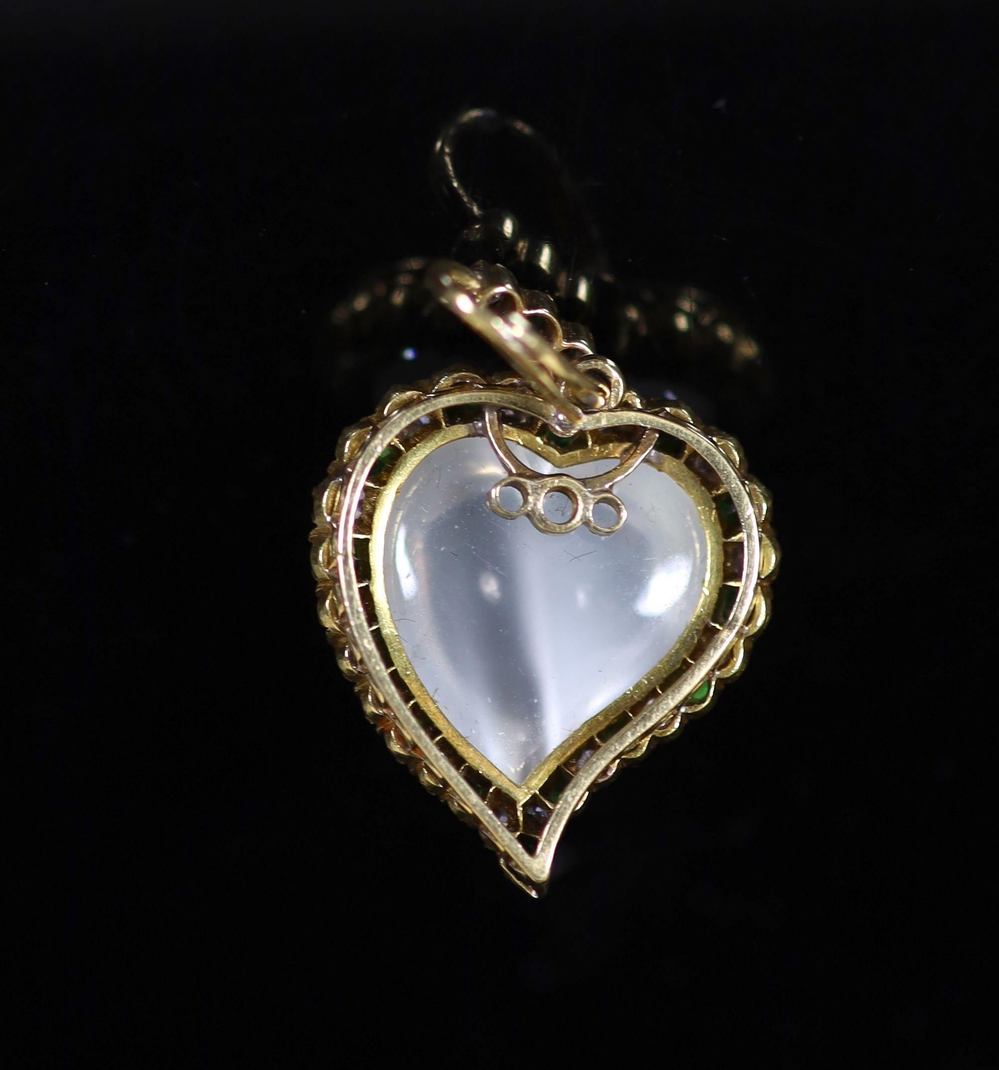An early 20th century gold, moonstone, diamond and green garnet set heart shaped pendant